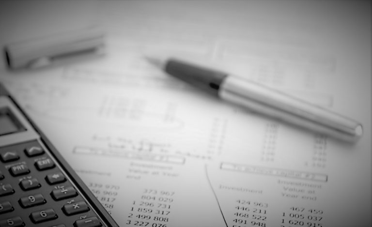Pen and calculator resting on a financial statement