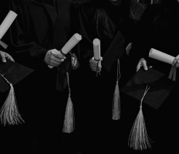 four-grad-students-caps-and-diplomas