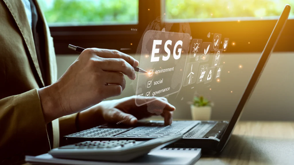 A hand on a laptop, with an ESG icon above the keyboard