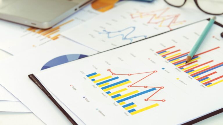 Charts and graphs printed on paper, with a pen