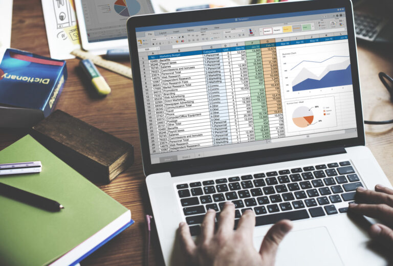 A laptop showing a spreadsheet on a desk