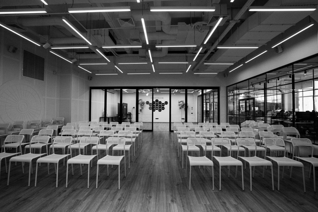 Rows of empty chairs set out for a conference in a bright modern room