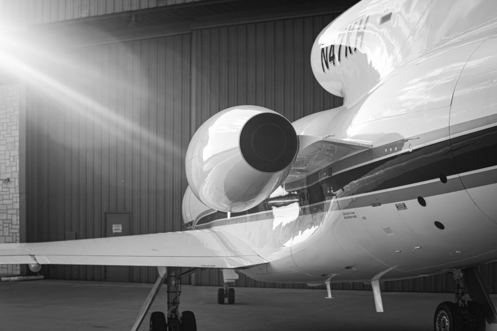 A private jet in a hangar, its engine catching the sunlight