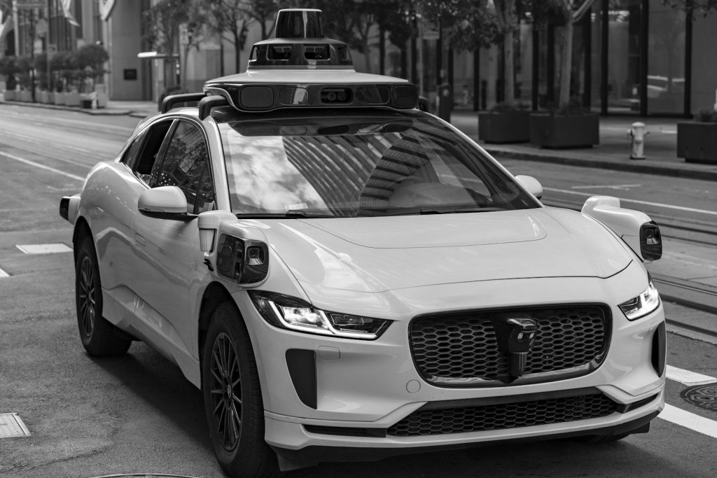 A self-driving test car with roof-mounted sensors on a city street