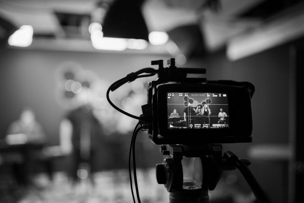 A professional video camera filming in a studio