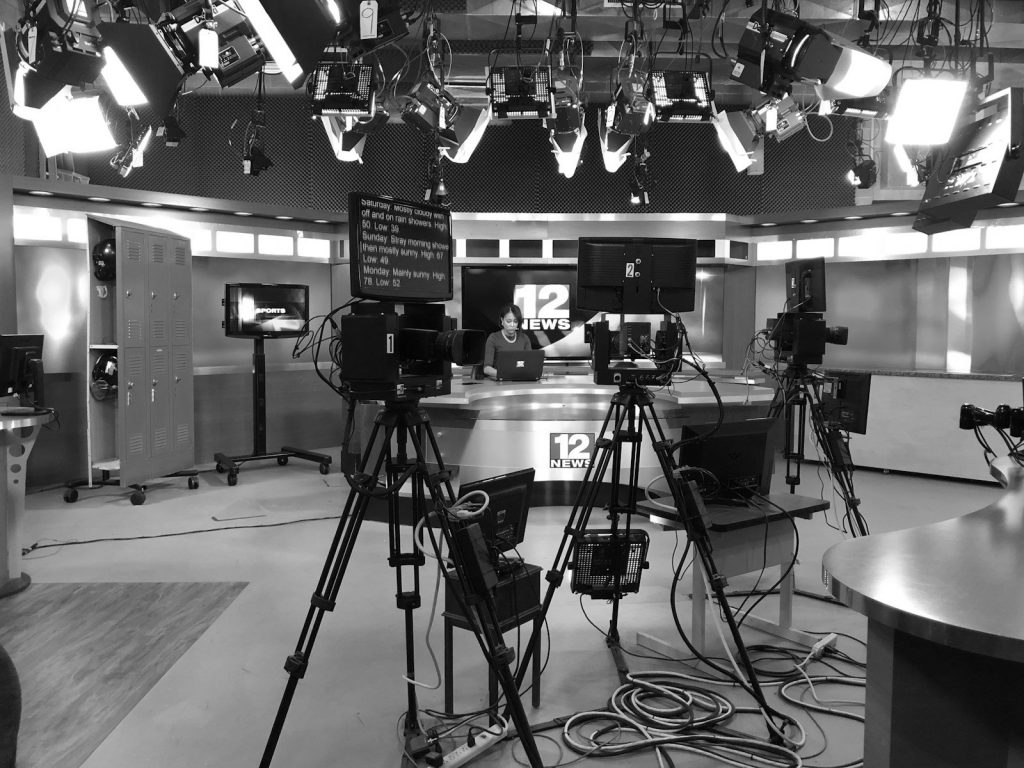 A television news studio with cameras and lighting rigs